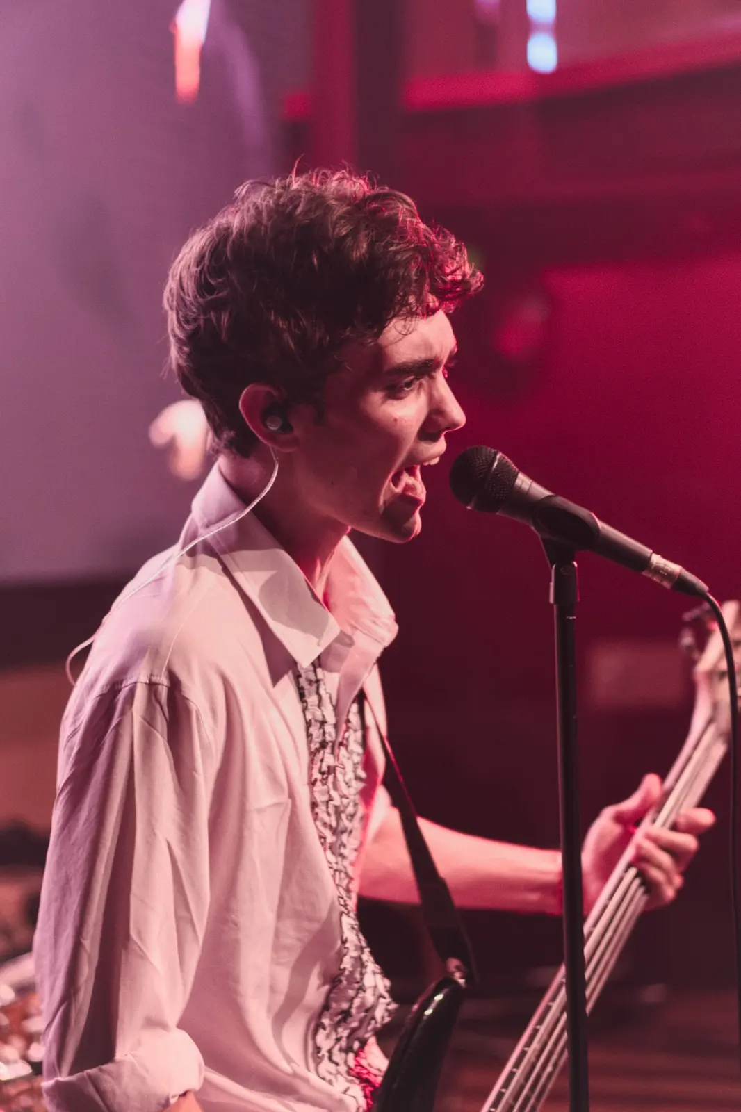 Vocalist performing under red stage light