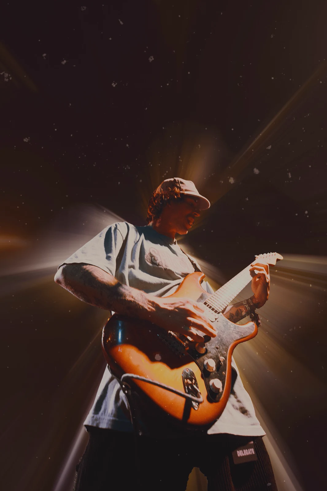 Low-angle guitarist photograph with warm light effects