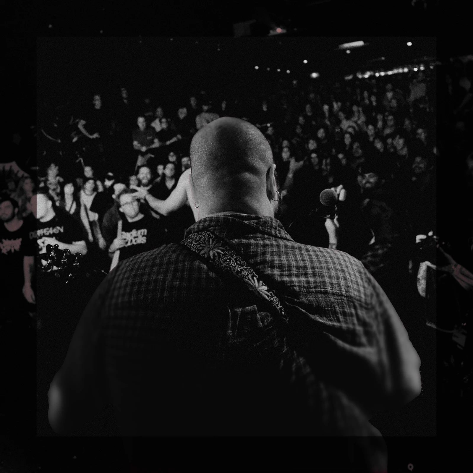 Black-and-white view from behind a performer towards the crowd