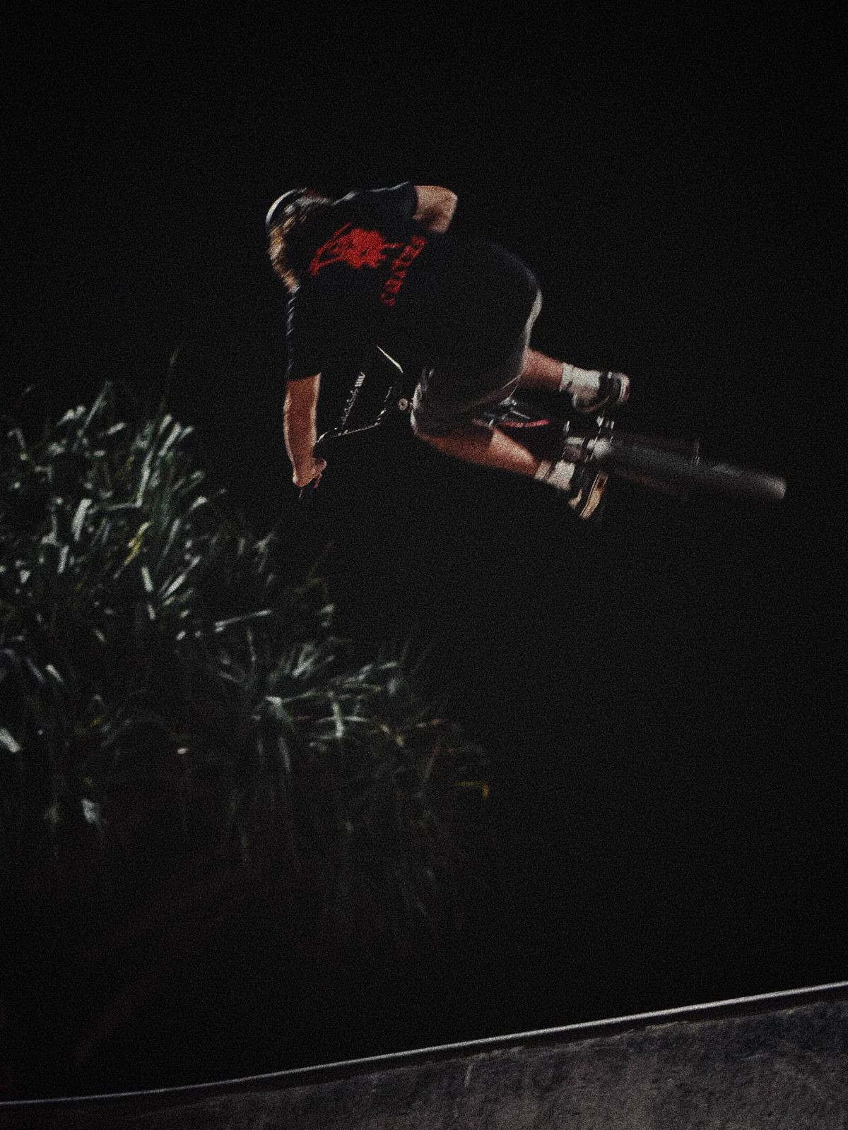 Lucas riding above the ramp with trees behind him