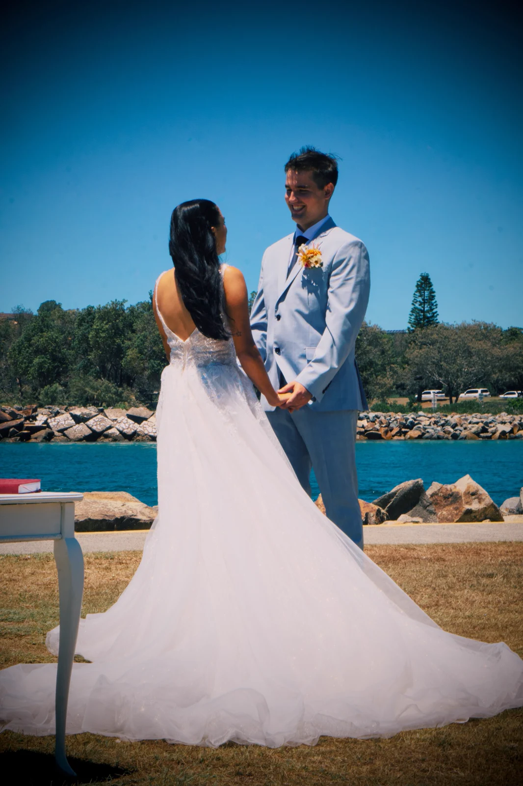 The couple holding hands beside the waterfront